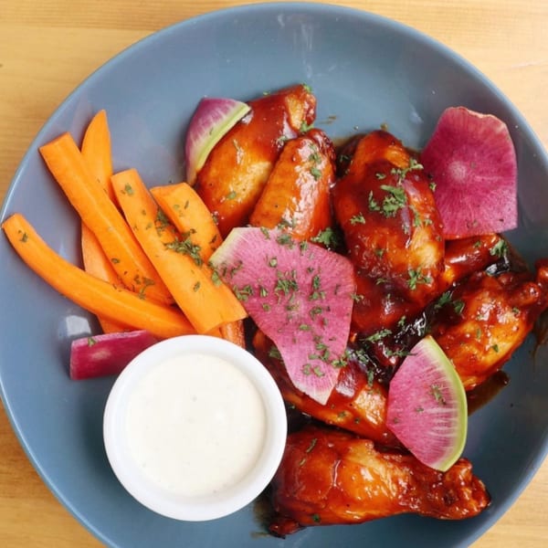 Ednas Market & Grille's New-American chicken wings with carrots, watermelon radish, and ranch dressing.