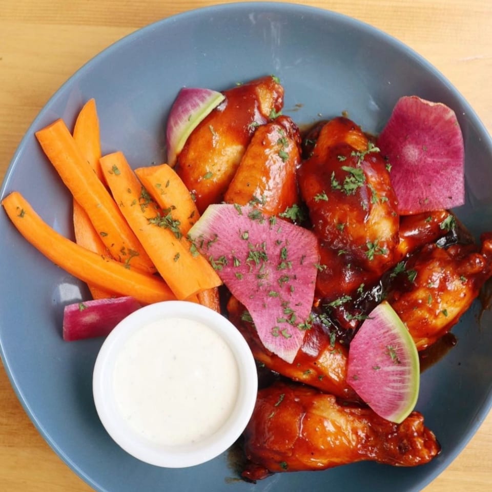 Ednas Market & Grille's New-American chicken wings with carrots, watermelon radish, and ranch dressing.