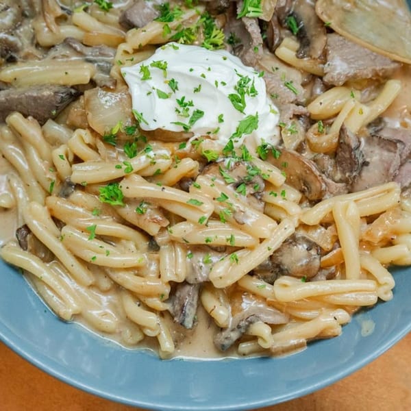 Beef stroganoff with cavatappi pasta, mushrooms, onions, and a dollop of sour cream with parsley.
